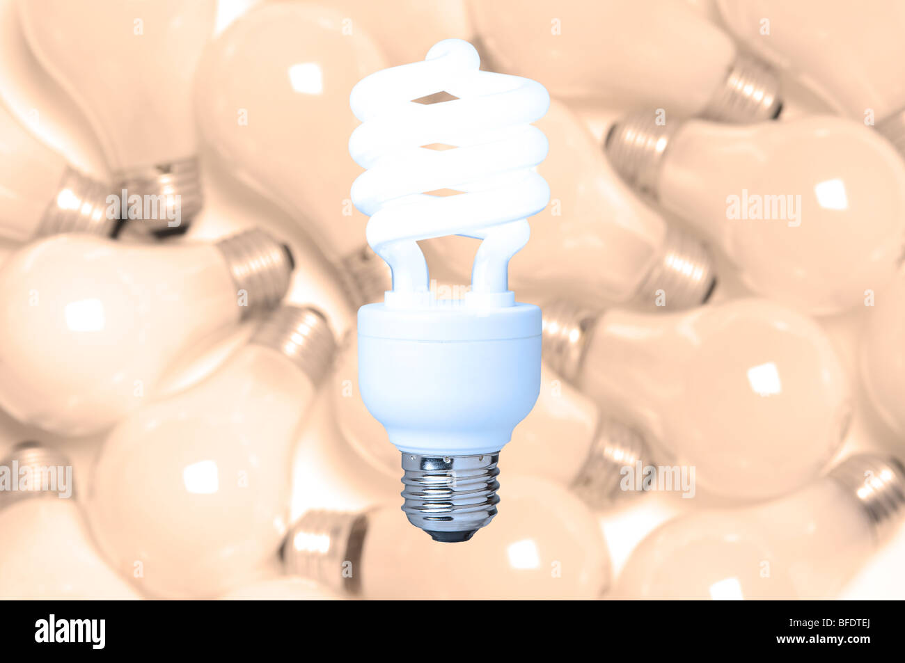 a compact fluorescent light bulb against a background of incandescent light bulbs Stock Photo