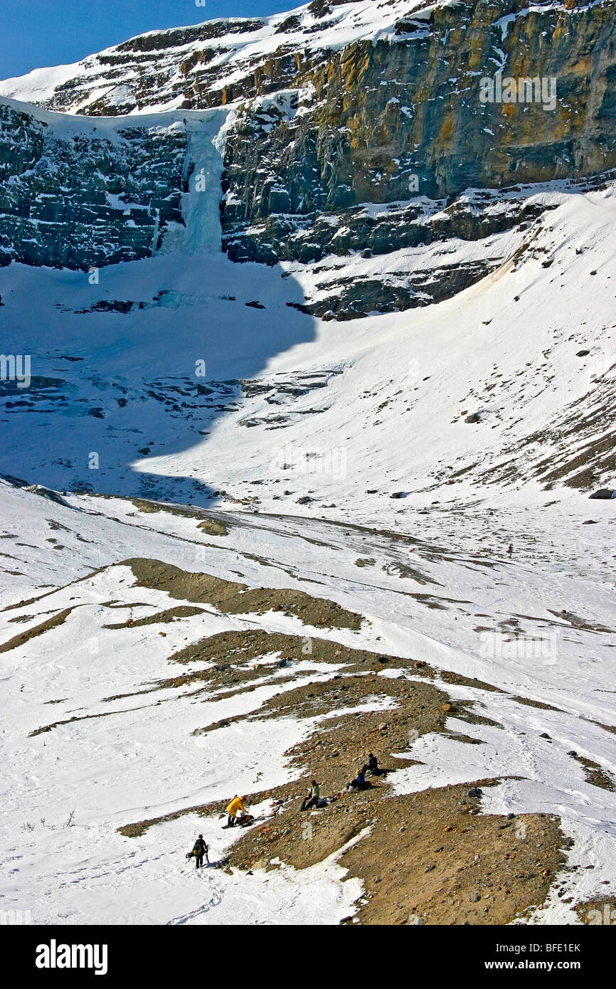 Skiers eat lunch in the shadow of Bow Lake Falls near Num Ti Jah Lodge
