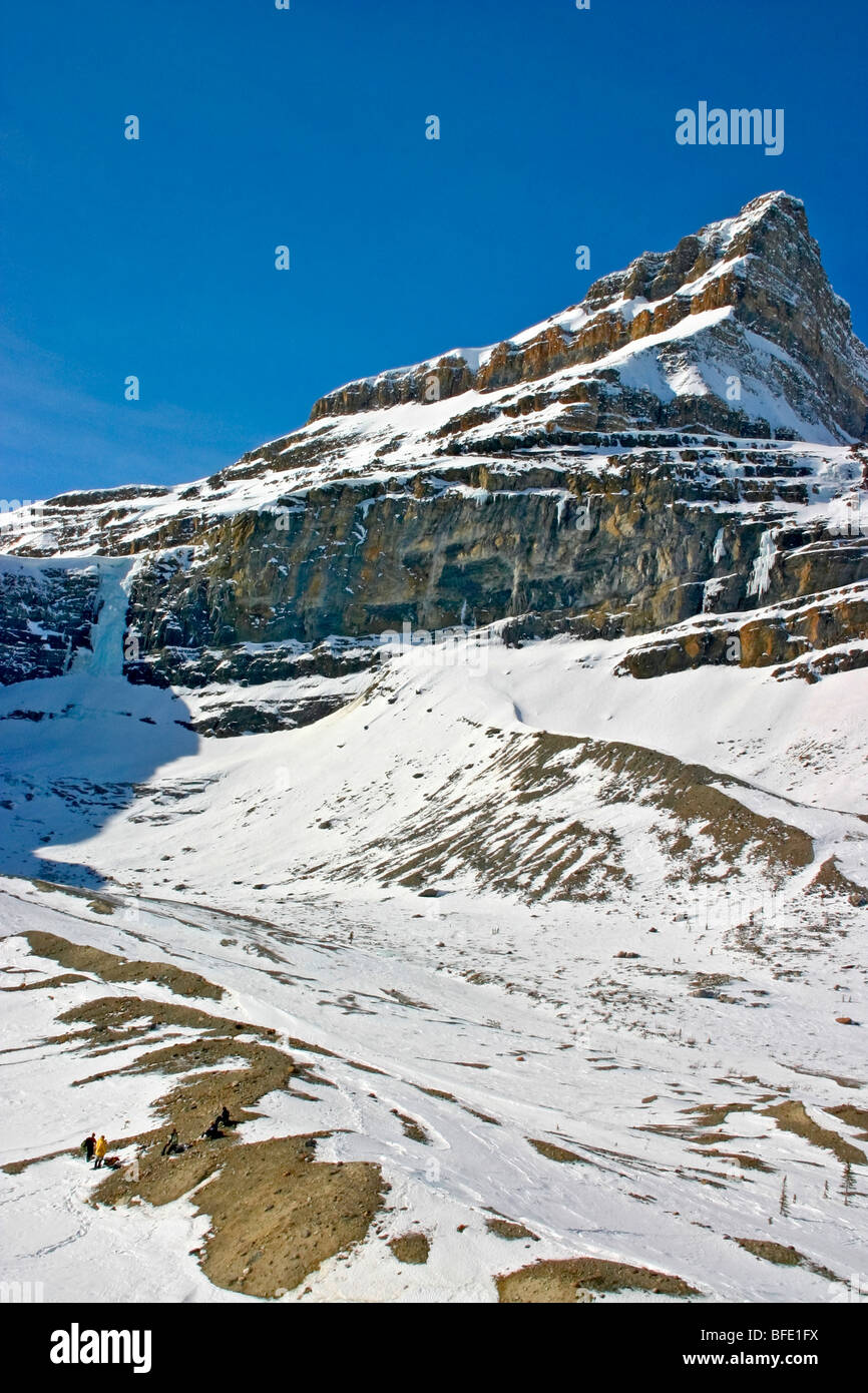 Skiers eat lunch in the shadow of Bow Lake Falls near Num Ti Jah Lodge