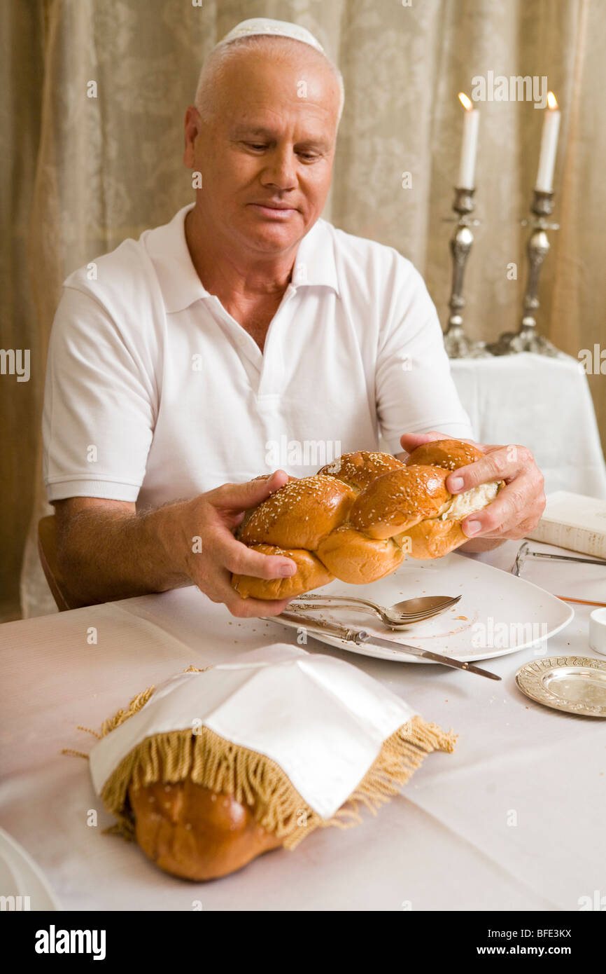 Man blessing on Challah bread at a festive family dinner. Stock Photo