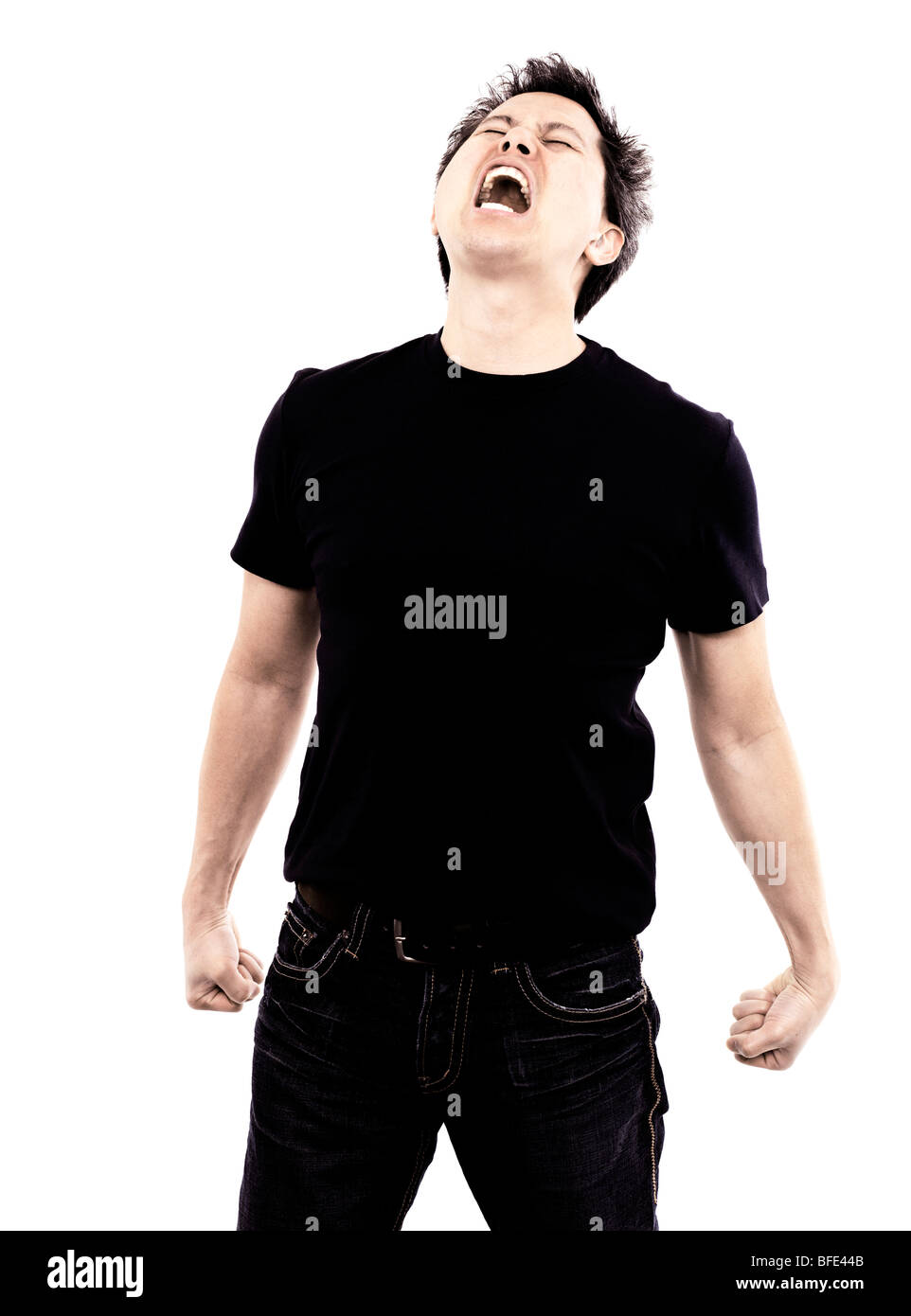 44 year old Asian male wearing jeans and a blue t-shirt standing against a white background screaming Stock Photo
