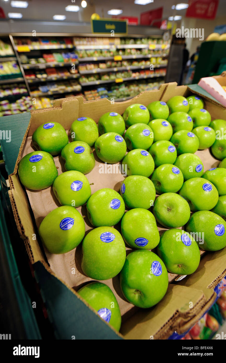 Bright green Granny Smith apples for sale in the fresh fruit and vegetable aisle in a UK supermarket. Stock Photo