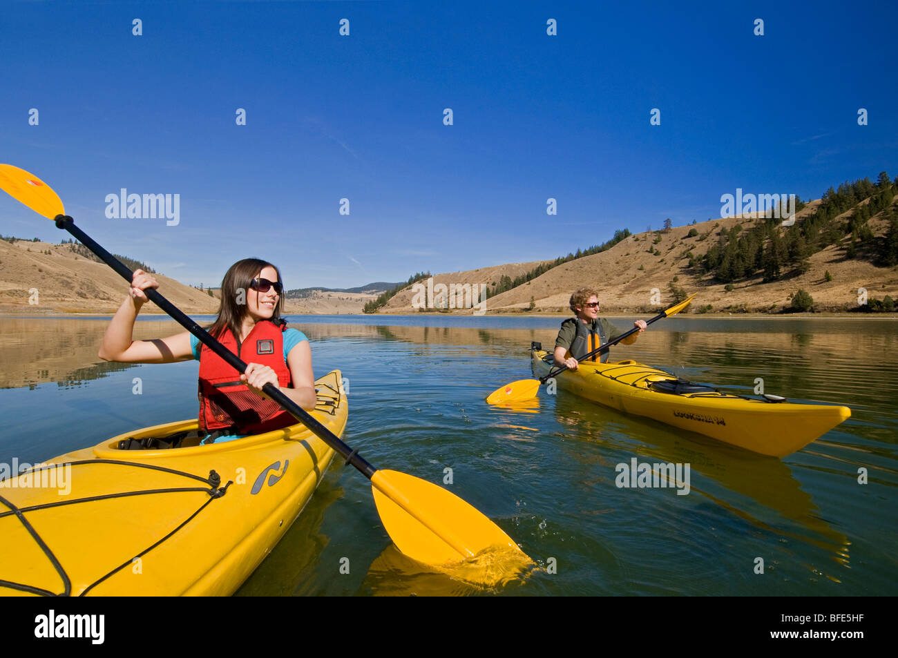 A young couple enjoys a stunning day while kayaking on Trapp Lake, just