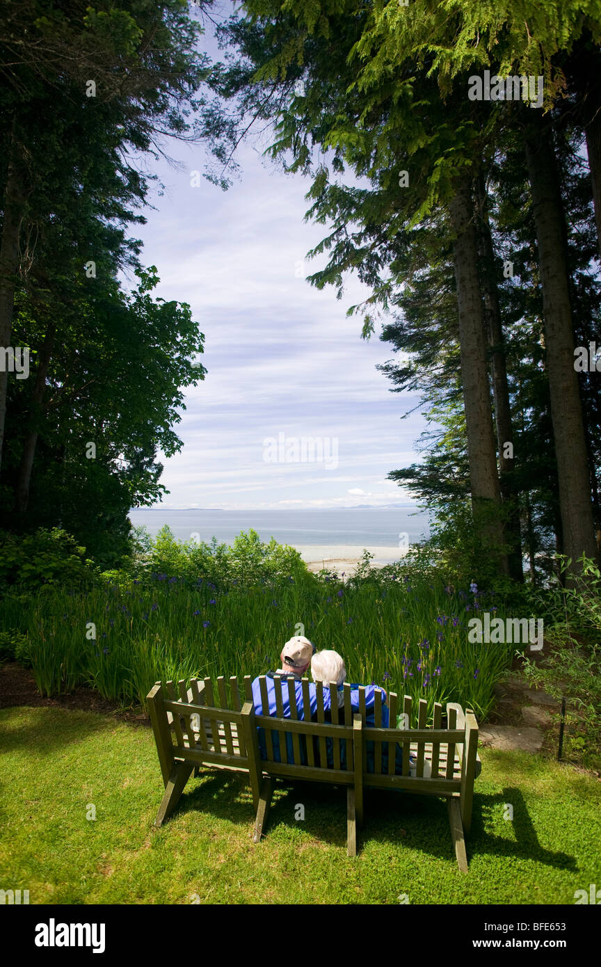 A senior couple sitting on a bench, Qualicum Beach, Vancouver Island, British Columbia, Canada Stock Photo