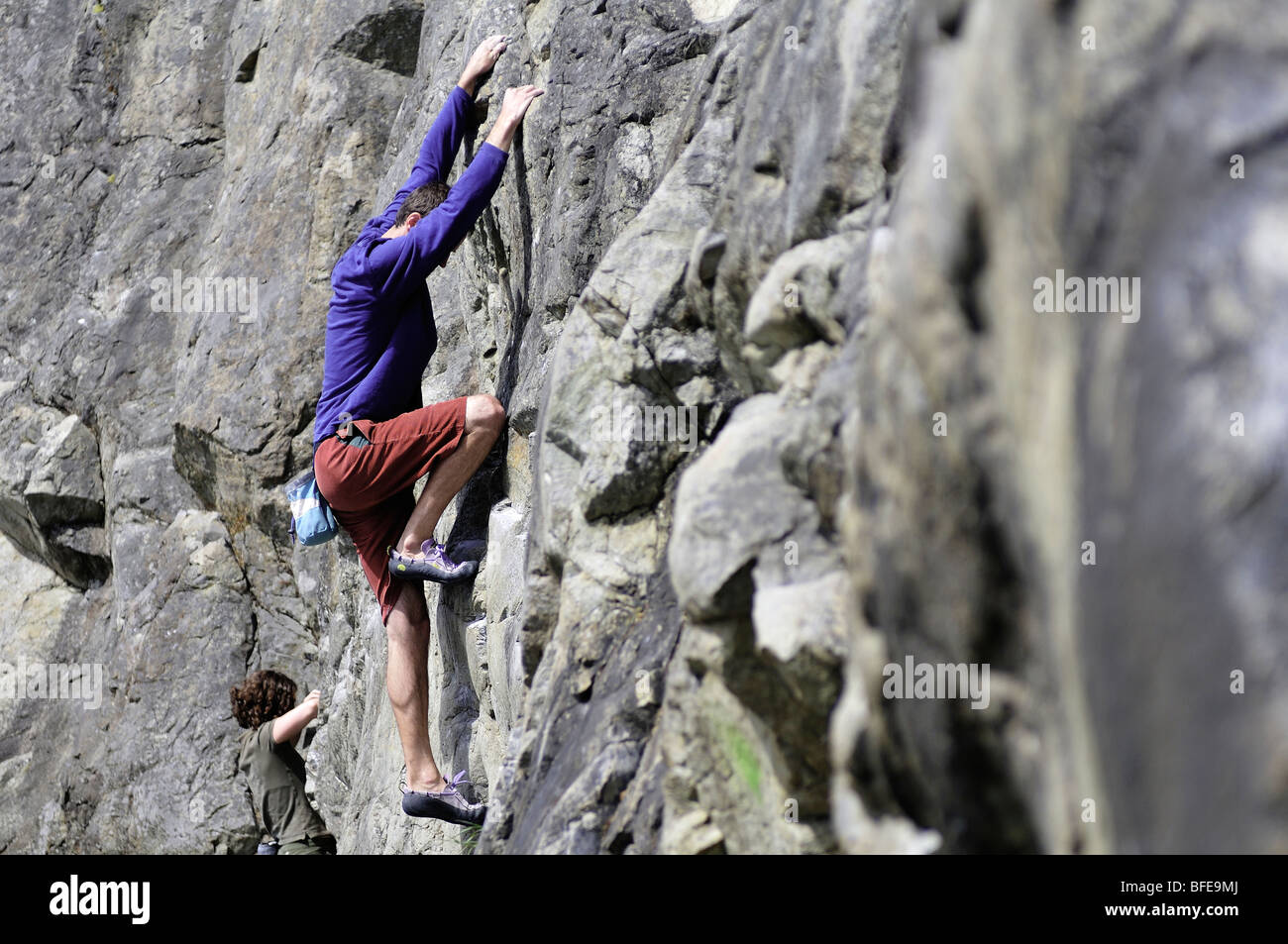 Young man and woman rock climbing in Macaulay Point Park, Victoria, Vancouver Island, British