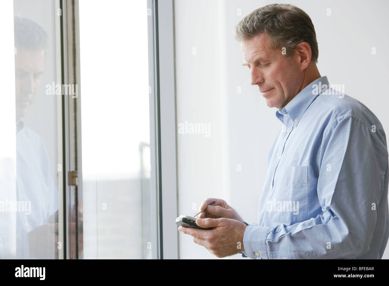 Middle-aged executive using a wireless pocket PC Stock Photo