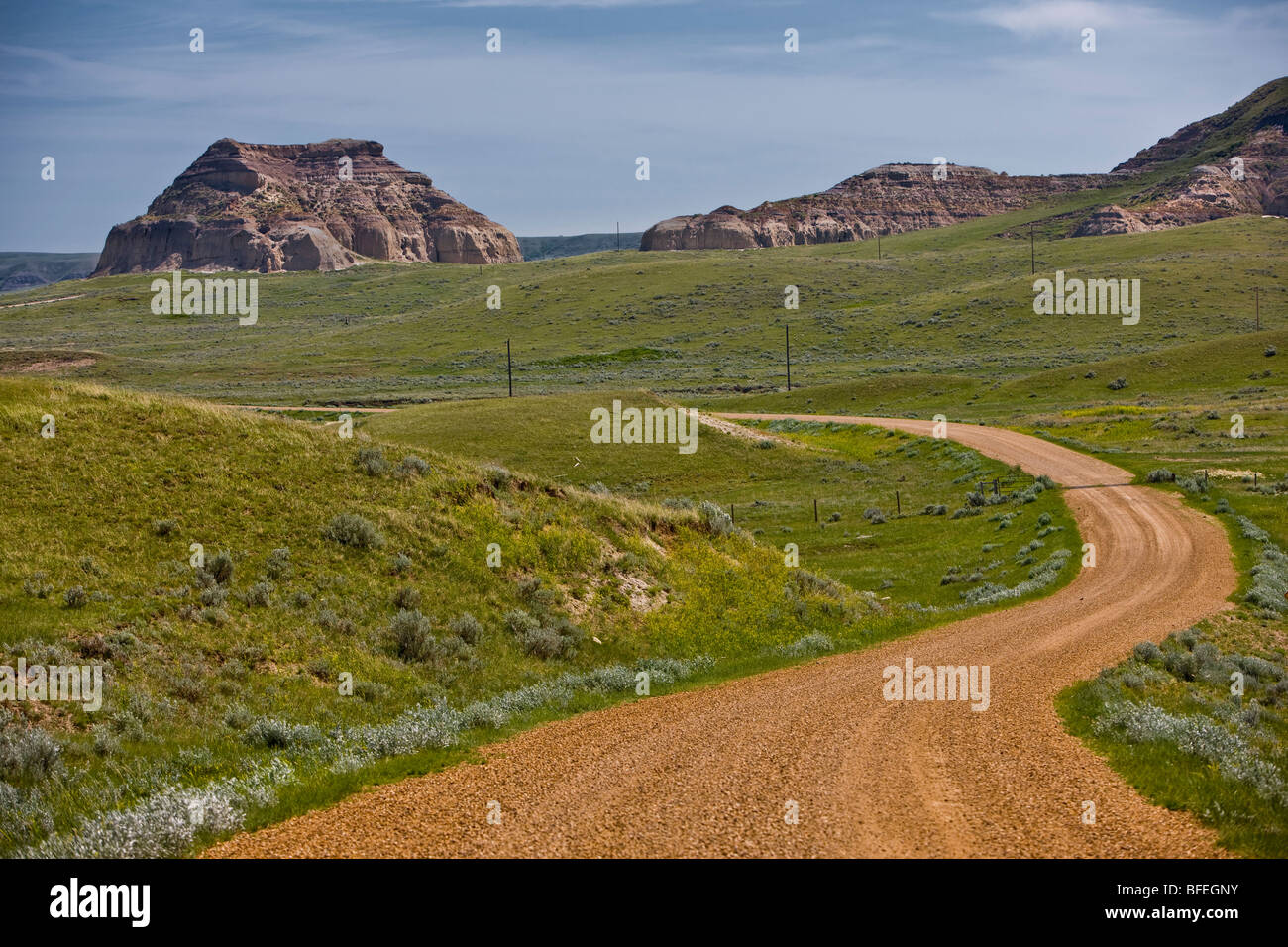Rural road and Castle Butte in the Big Muddy Badlands of southern Saskatchewan, Canada Stock Photo