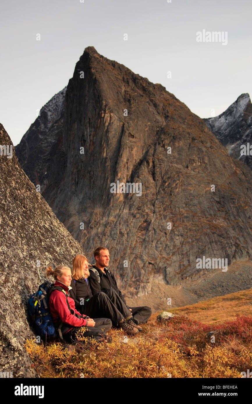 Hikers taking a break on rock while climbing in Tombstone Territorial Park, Yukon, Canada Stock Photo