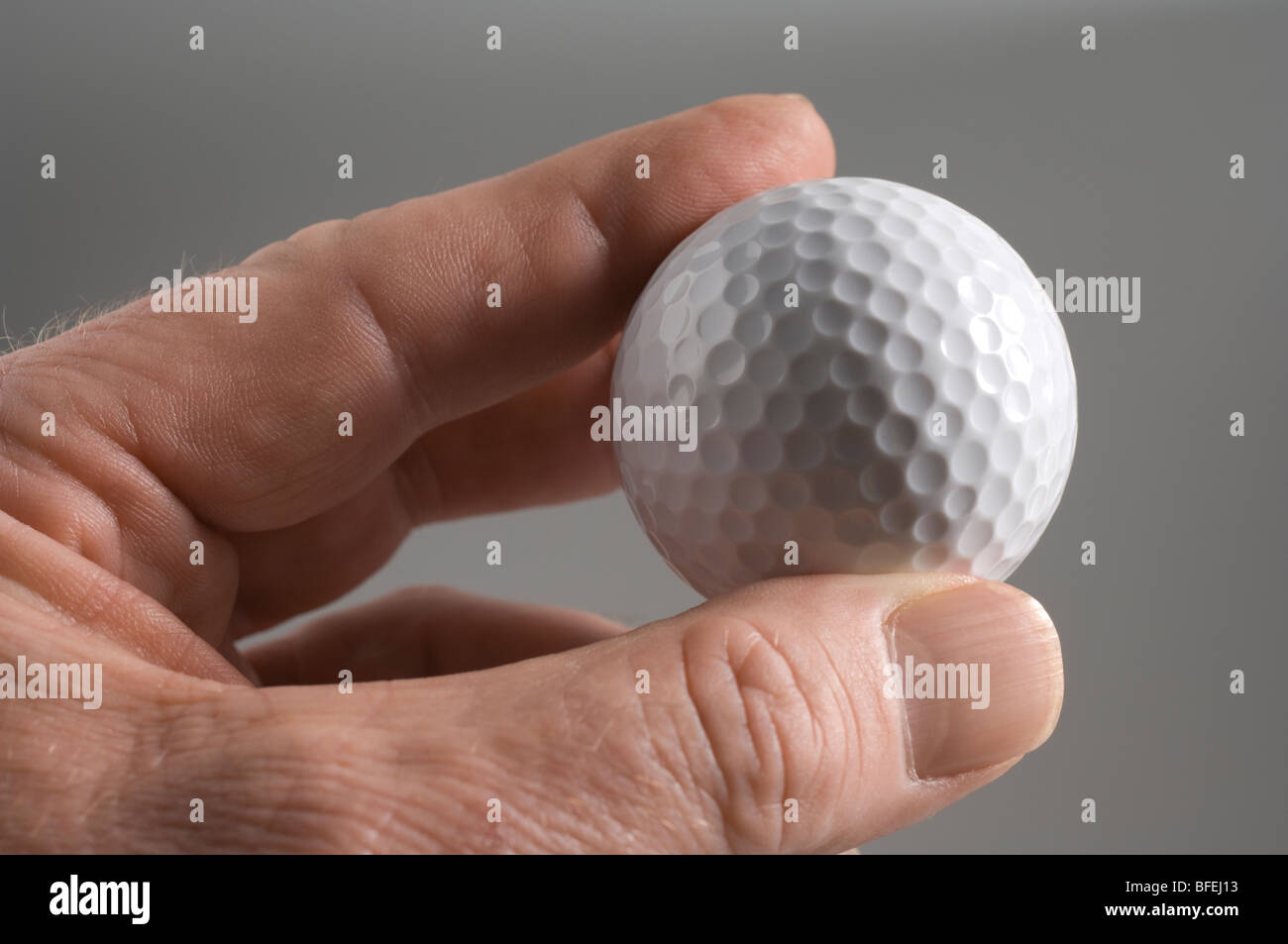 A man's hand holding a golf ball Stock Photo