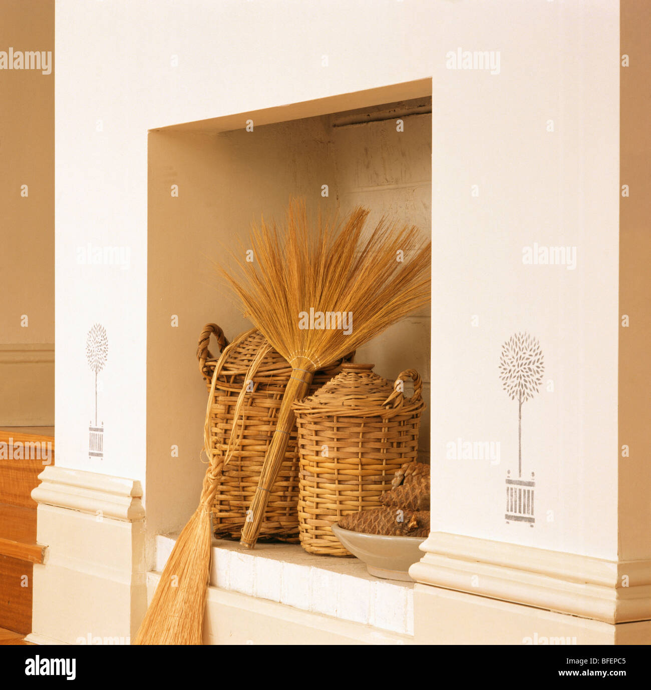 Wicker bottles and brush in kitchen alcove with stencils on outer wall