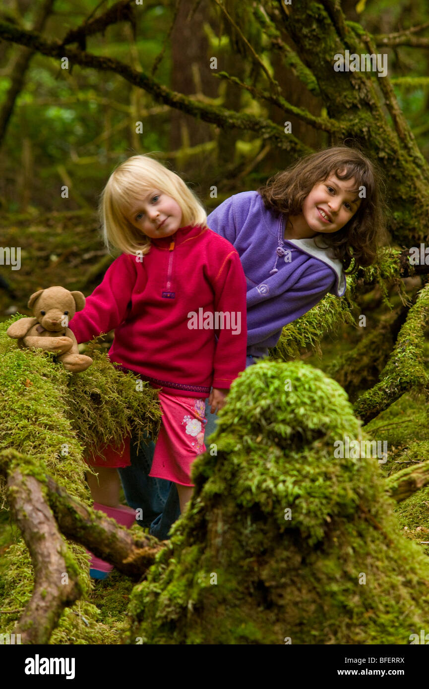 Two children in mossy forest, Naikoon Provincial Park, Queen Charlotte Islands, British Columbia, Canada Stock Photo