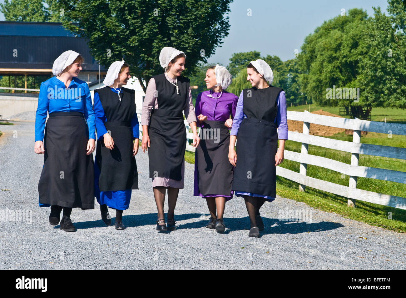 Young amish women friends walking down country lane road in Lancaster PA.   housewives Stock Photo