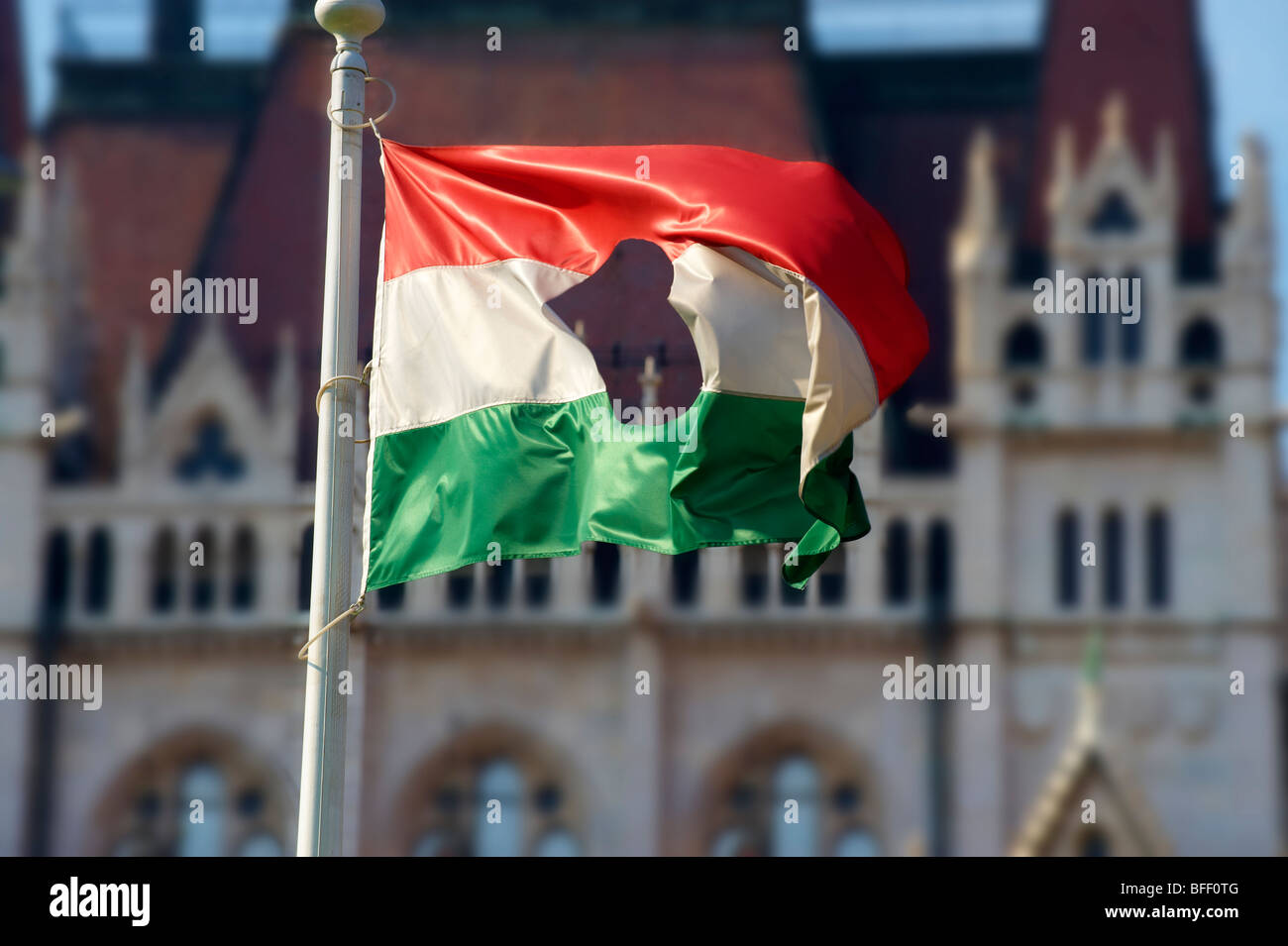 Flag with a hole in it commemorating the 1956 uprising outside Parliament, Budapest, Hungary Stock Photo