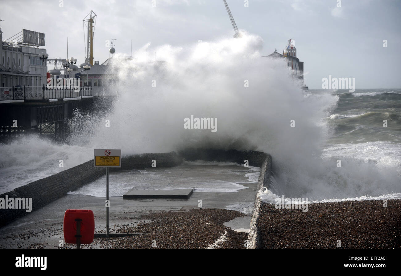 Huge waves crash over a groyne by the Palace pier Brighton during a storm on the seafront UK Stock Photo