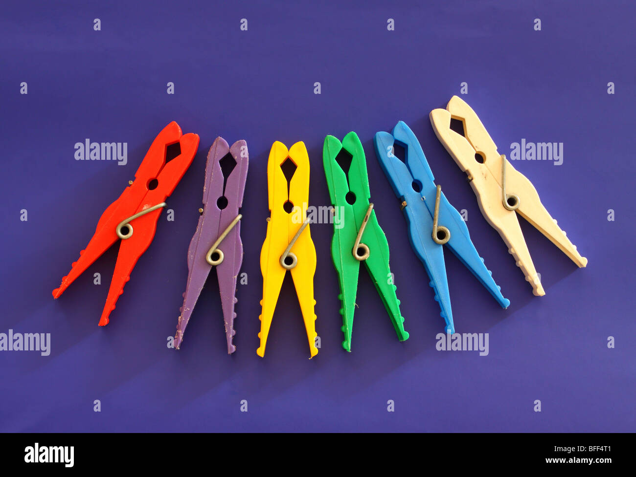 Multicolor laundry clips on blue background Stock Photo