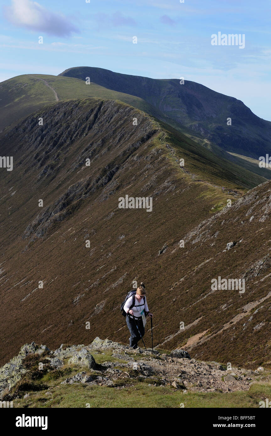 Female Fell walker ascending Causey Pike with Scar Crags behind her in