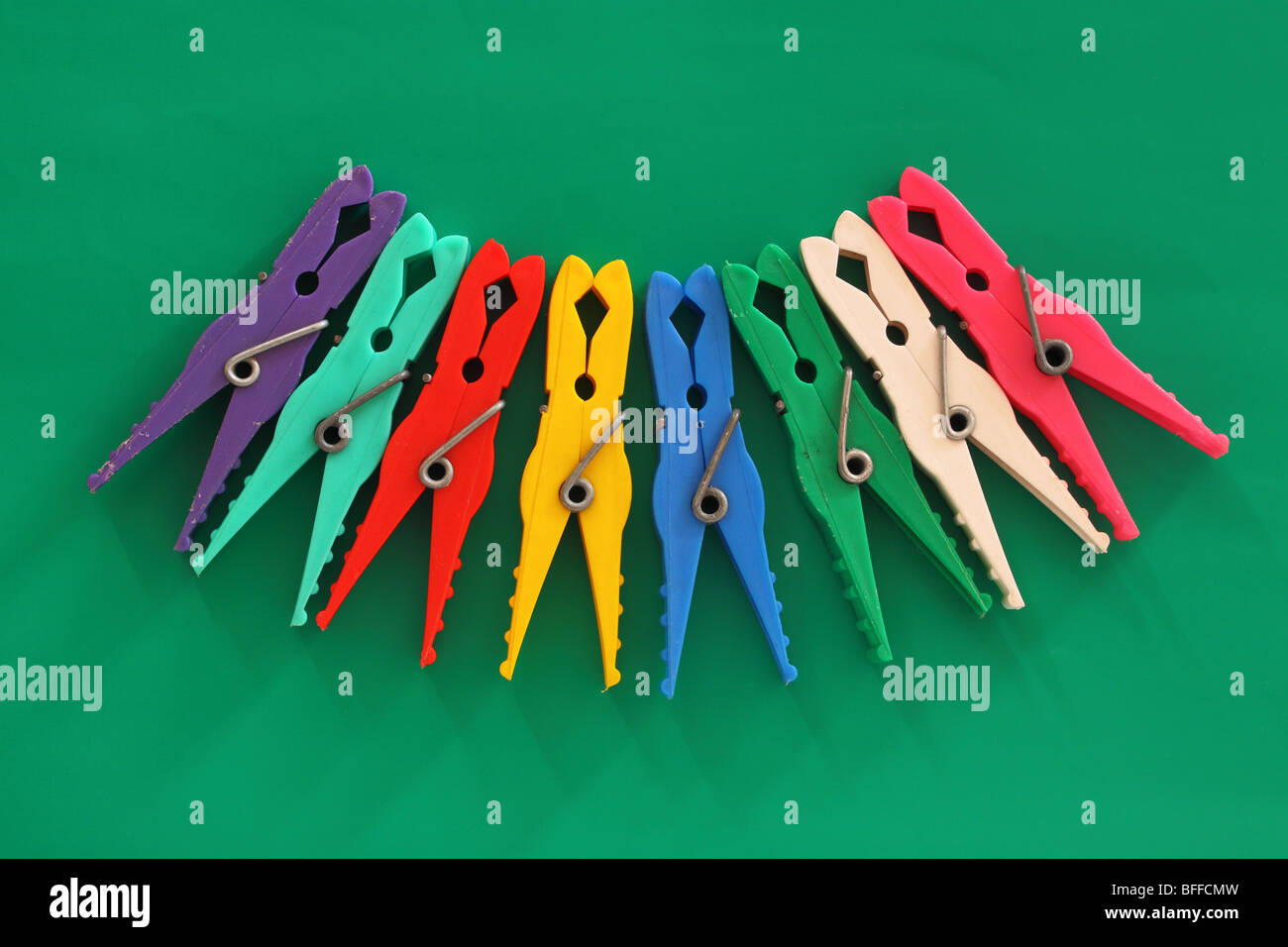 Multicolor laundry clips on green background Stock Photo