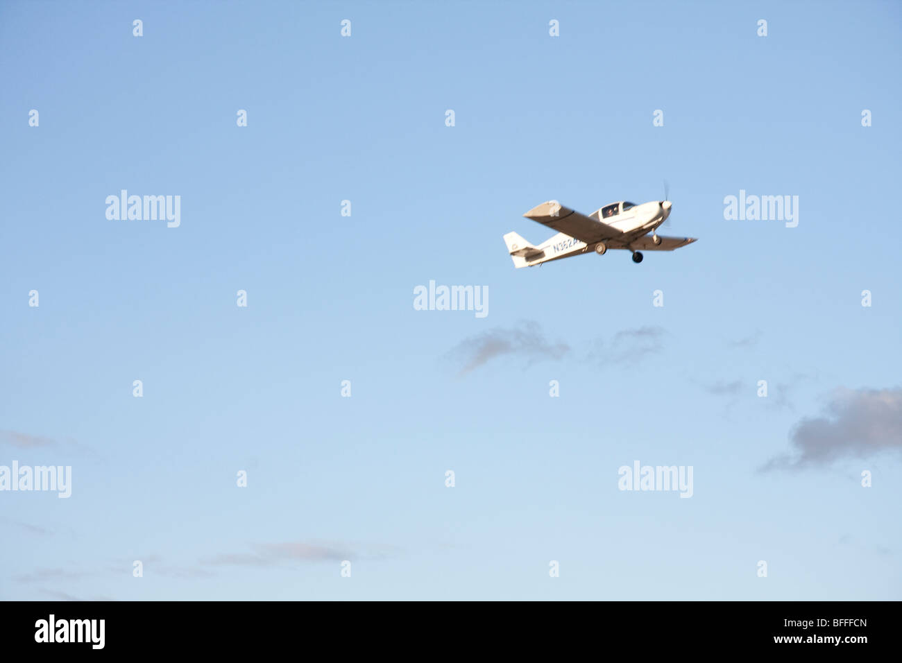 Small plane (crop duster) flying low over central valley fields, California Stock Photo