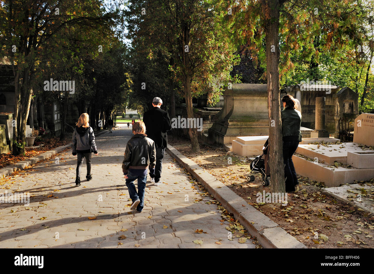 Paris, France - Street Scene, Young Family Walking from Behind Promenading in 'Pere Lachaise Cemetery', Autumn Stock Photo