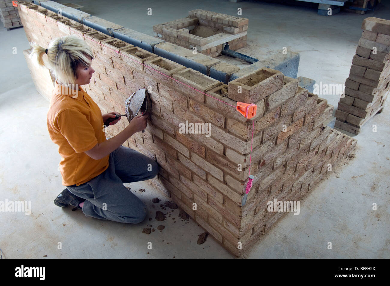 Girl student learning practical bricklaying  at a City College Stock Photo