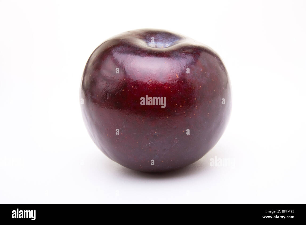 Shiny purple plum isolated against white background. Stock Photo