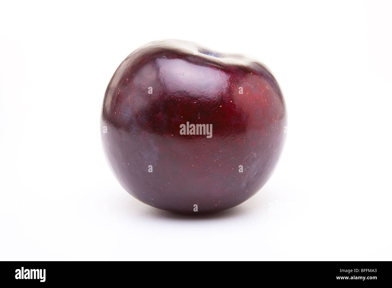 Shiny purple plum isolated against white background. Stock Photo