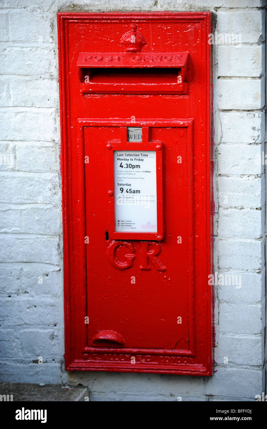 A  red King George VI postbox in a brick wall Stock Photo