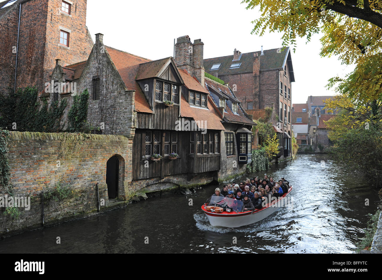 Tourists taking a boat trip on the canals at Bruges in Belgium Europe Stock Photo