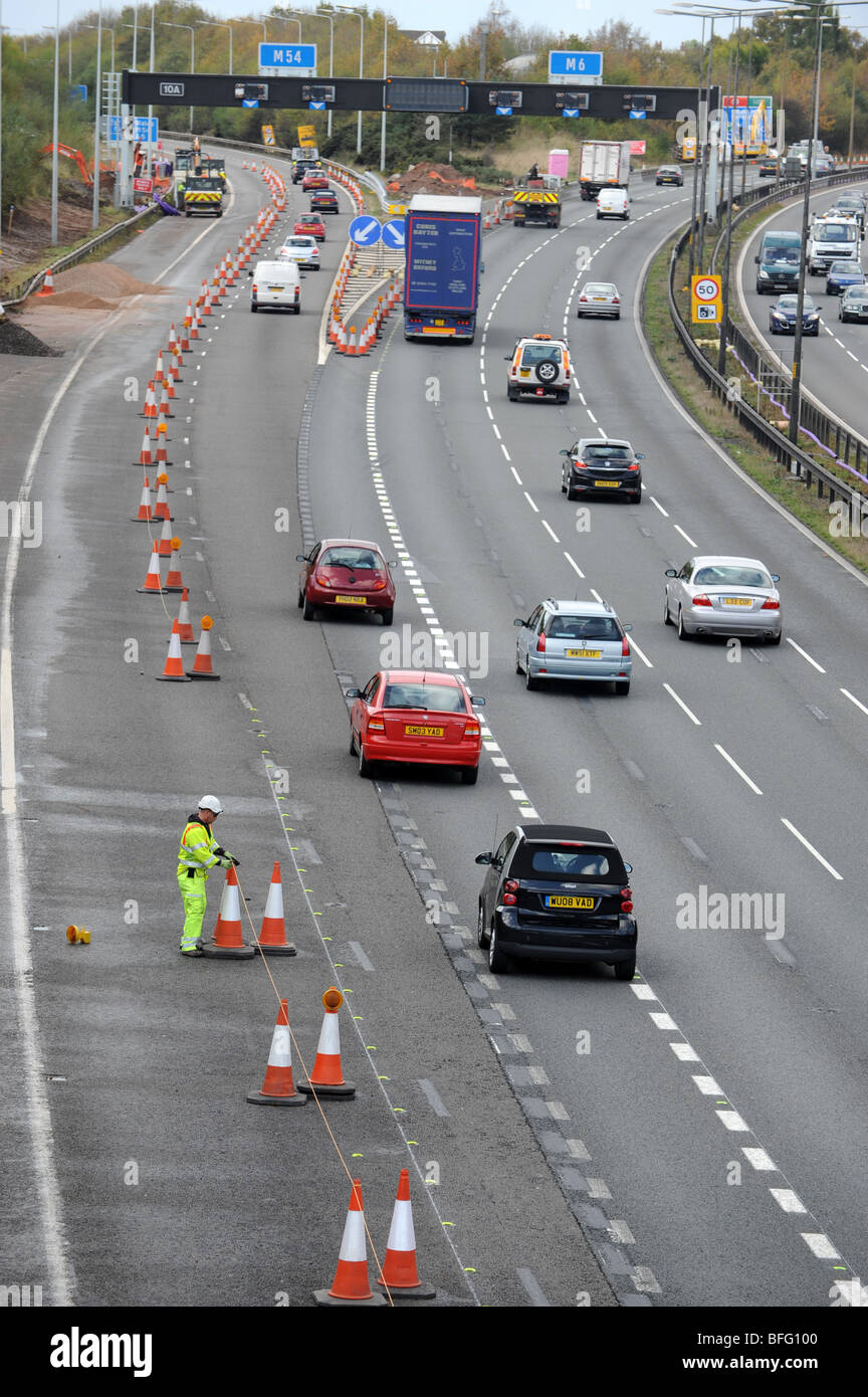 Highways worker putting traffic cones on M6 motorway junction with the M54 Stock Photo