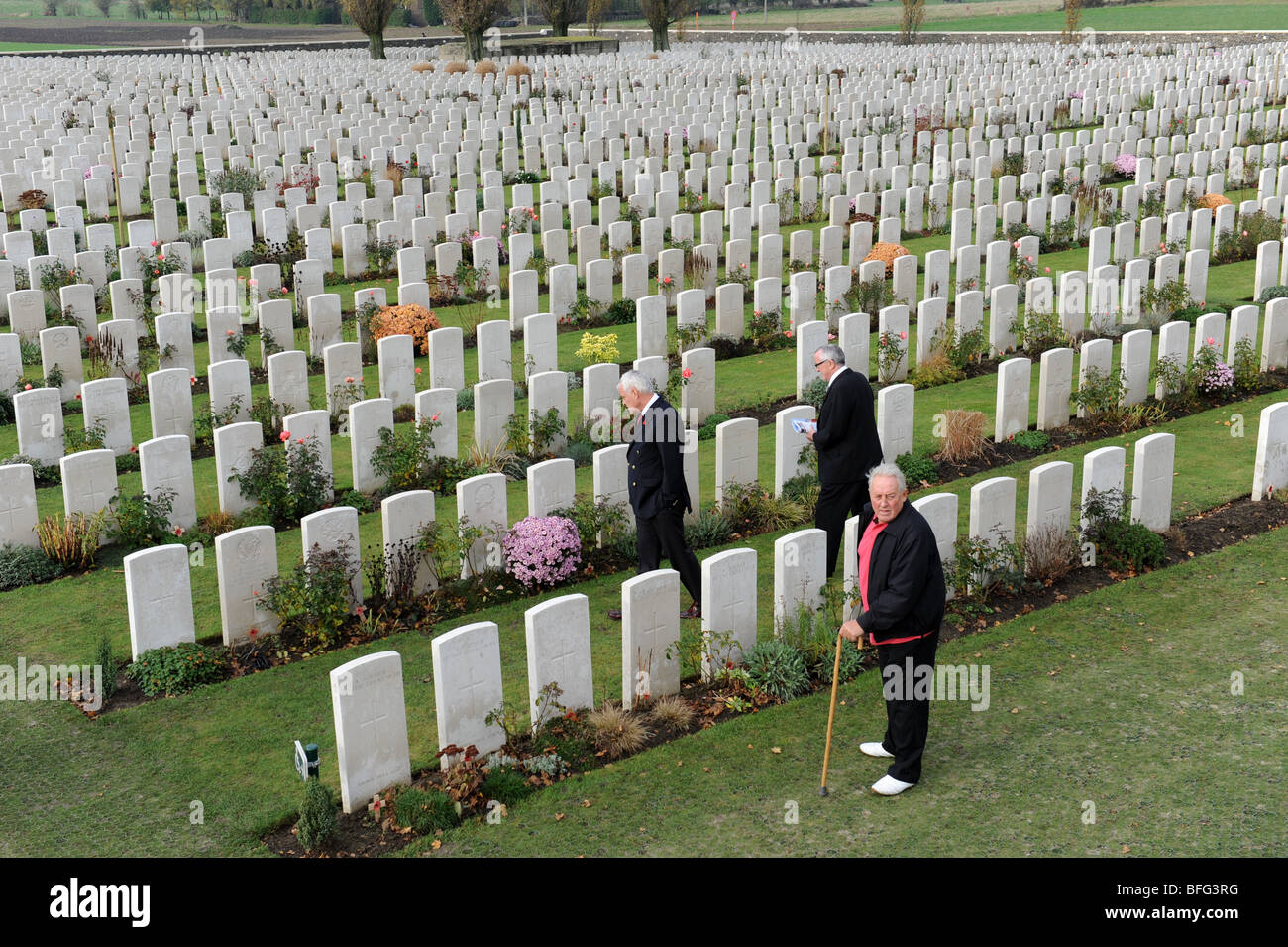 Visitors looking at the Graves of First World War soldiers at Tyne Cot Cemetery Passchendale Ypres Belgium Stock Photo