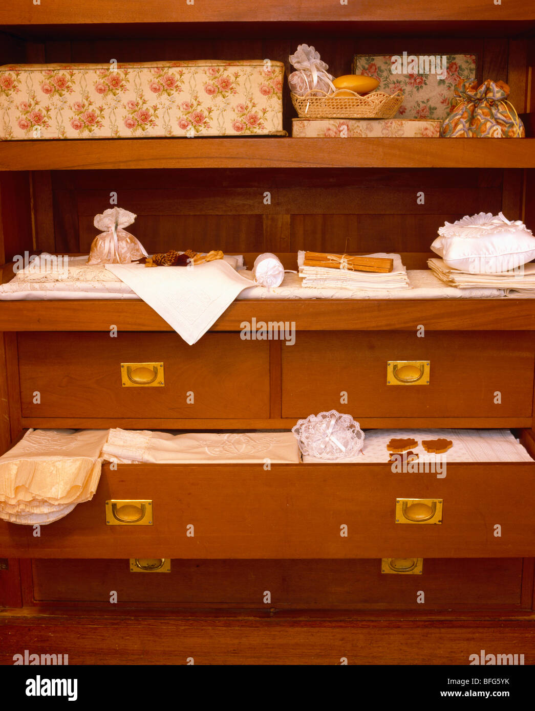 Close-up of floral boxes on shelves and storage drawers with bedlinen Stock Photo