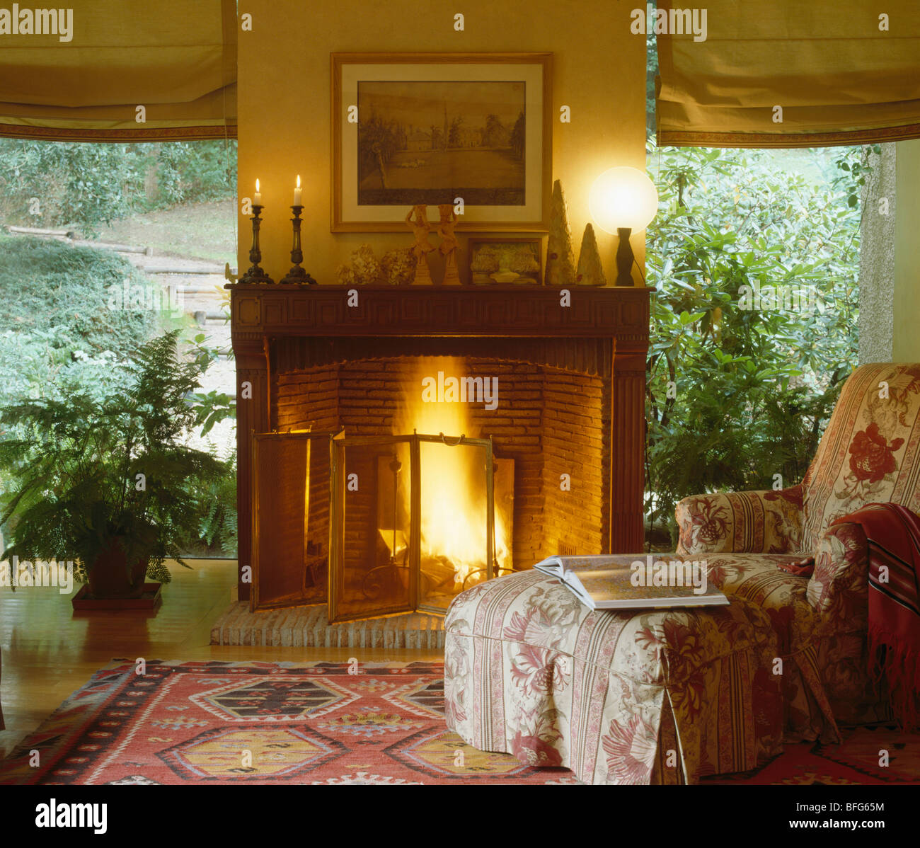 Lighted Fire In Fireplace With Lighted Candles On Mantelpiece