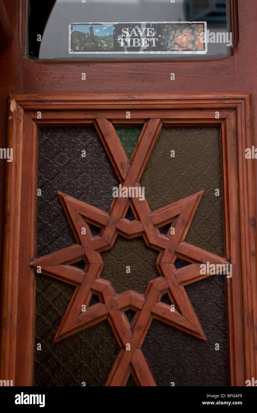 A door features a carved star and a Free Tibet sticker, in Essaouira, Morocco Stock Photo