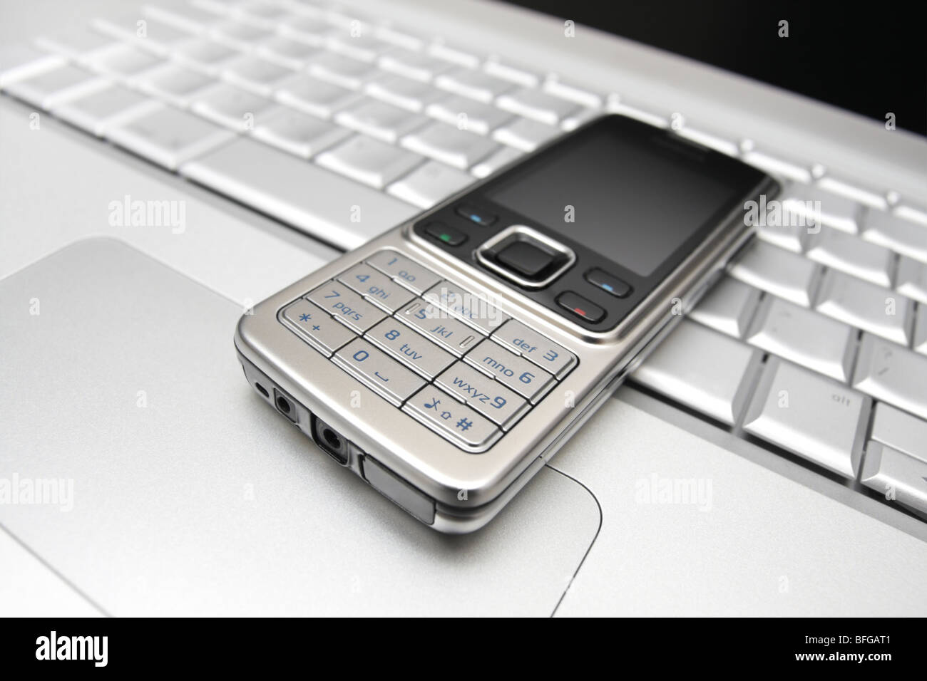 Mobile phone on a laptop keyboard Stock Photo Alamy