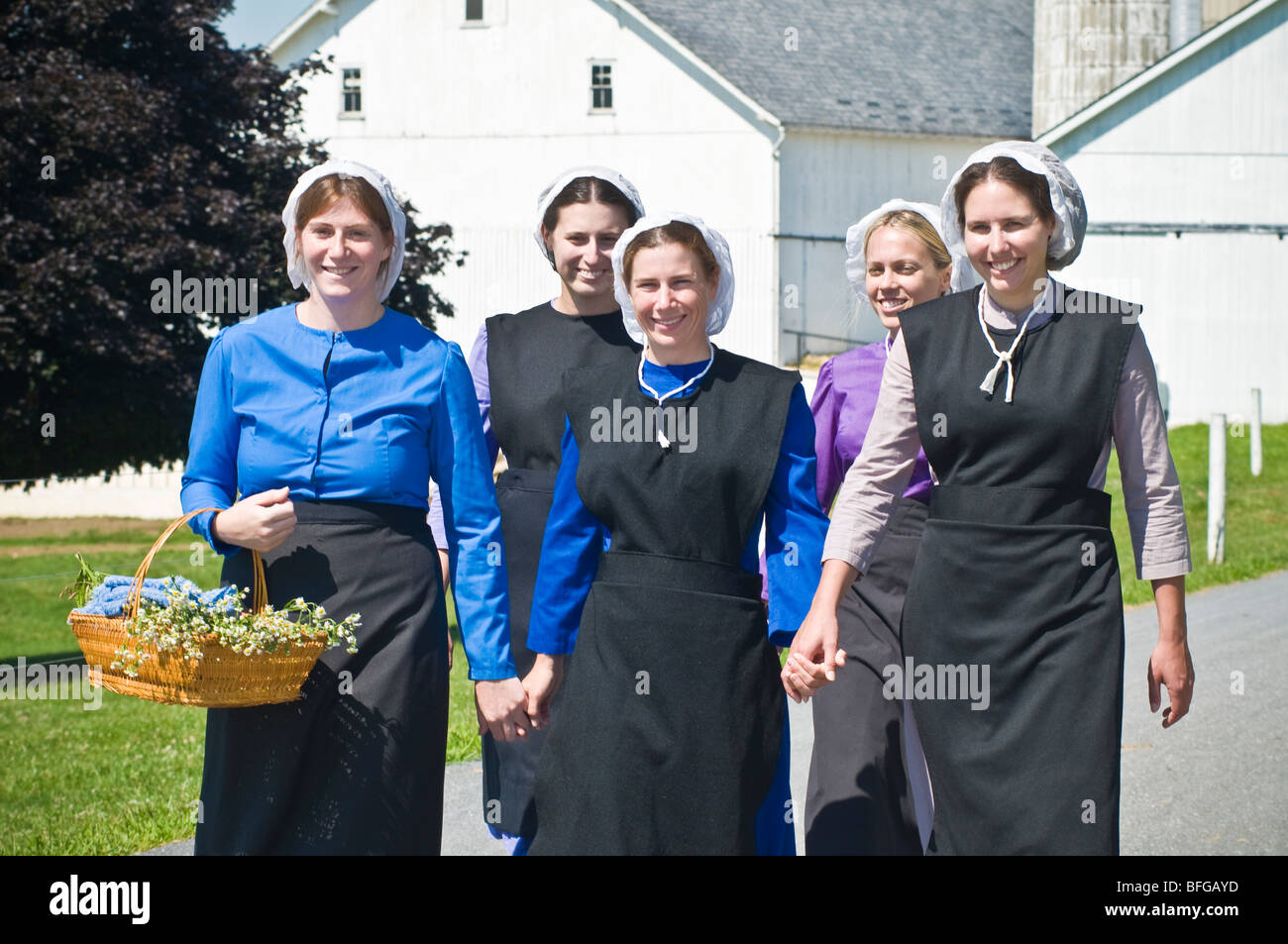 Young amish women friends walking down country lane road in Lancaster PA.   housewives Stock Photo