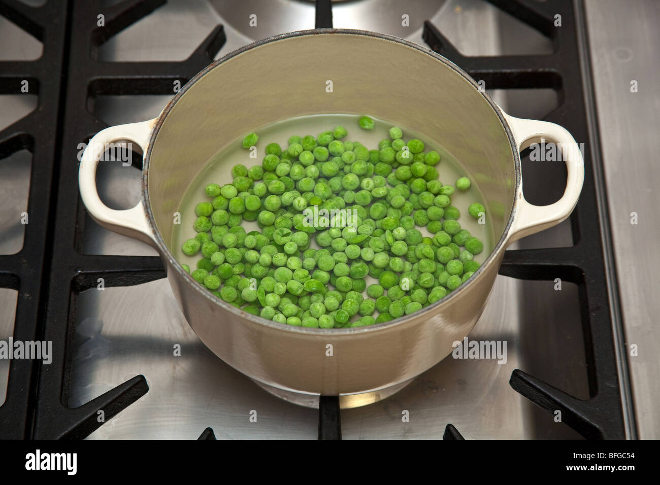 Garden peas cooking on a gas stove Stock Photo Alamy