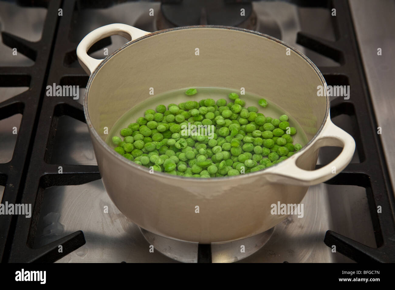 Garden peas cooking on a gas stove Stock Photo Alamy