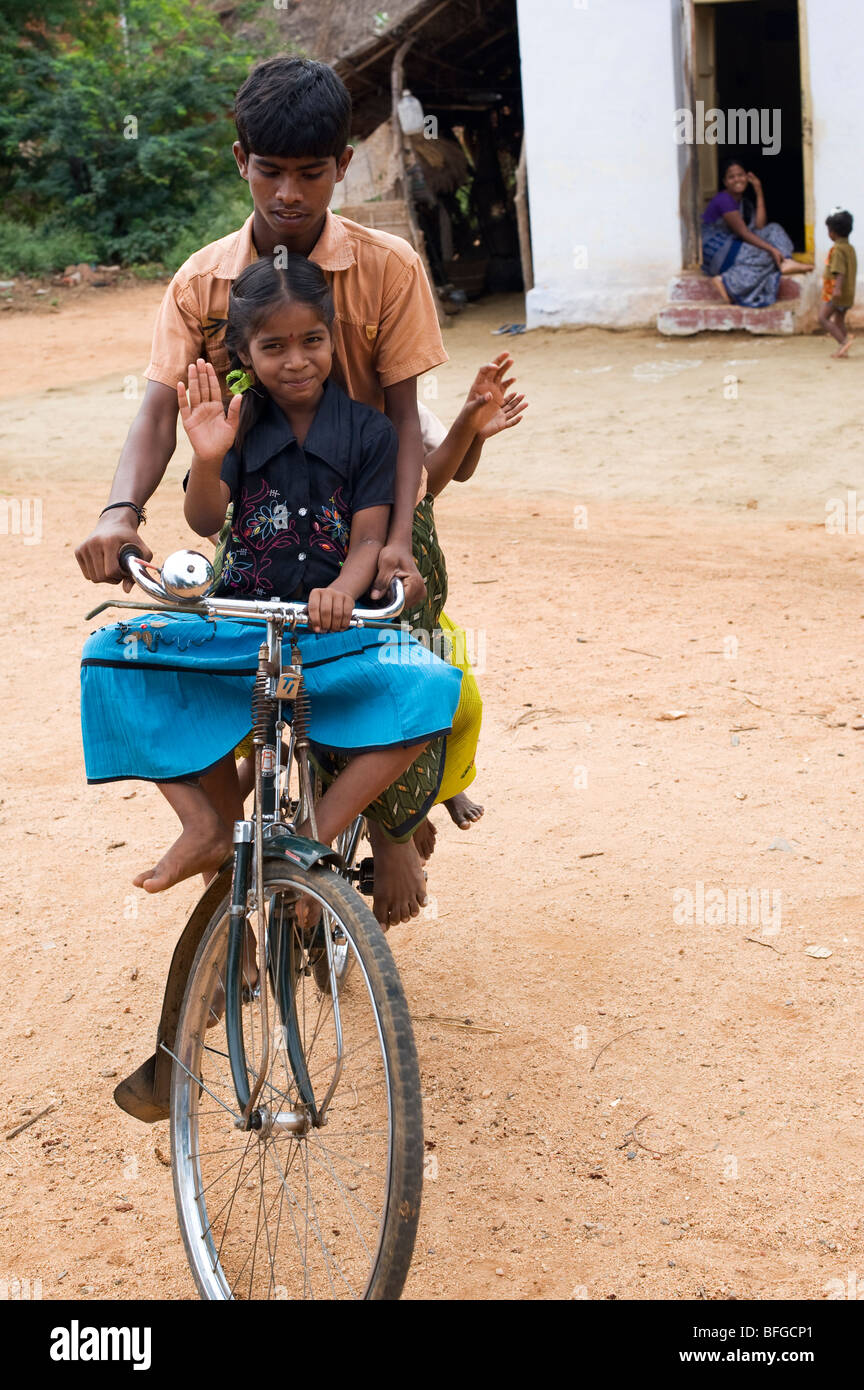 Indian teenager and children riding a bicycle in a rural Indian village. Andhra Pradesh, India Stock Photo