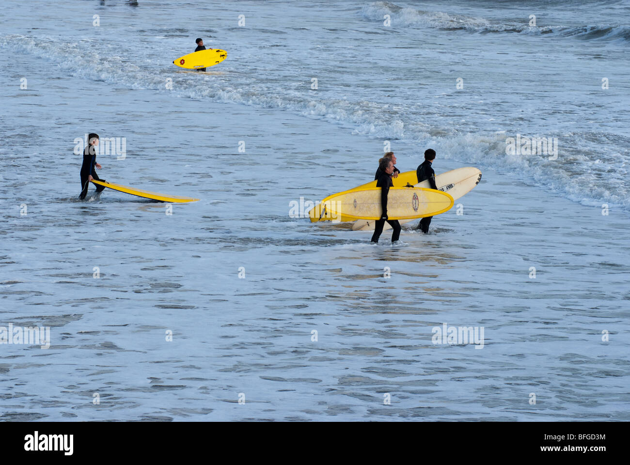 Surfers carry their boards into the sea at Bournemouth