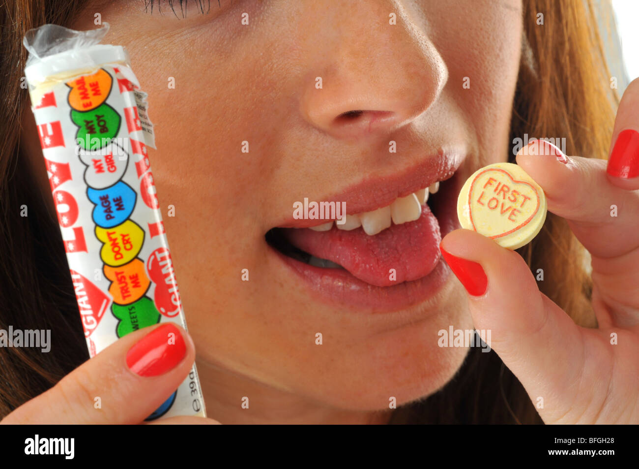 “Love hearts” sweets, Woman eating “Love hearts” sweet Stock Photo