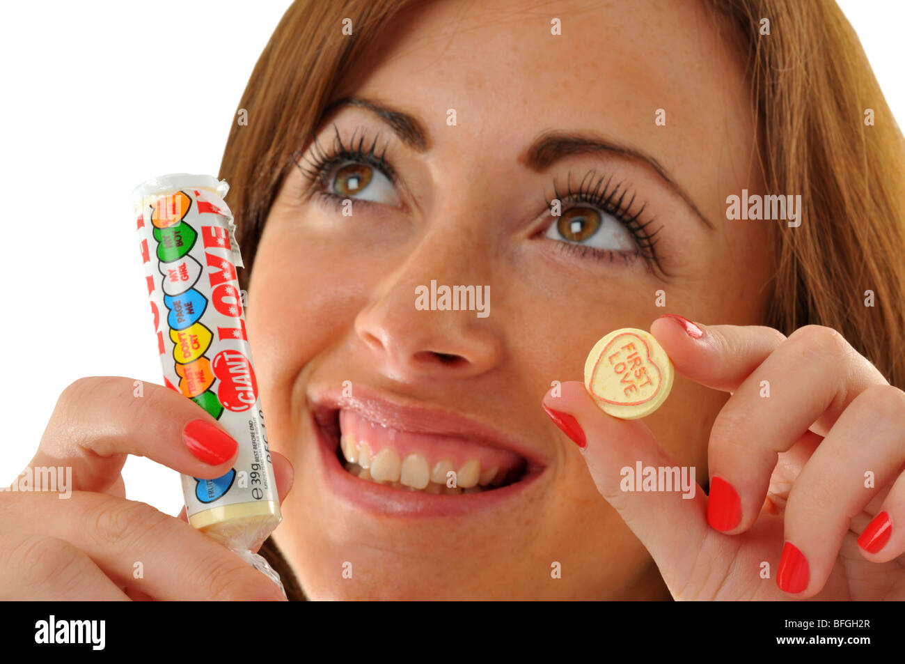 “Love hearts” sweets, Woman eating “Love hearts” sweet Stock Photo