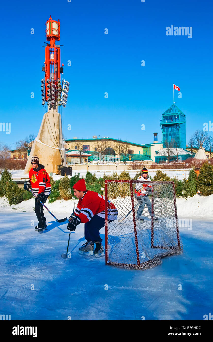 Young men playing ice hockey on The Assiniboine River, at The Forks, Winnipeg, Manitoba, Canada Stock Photo