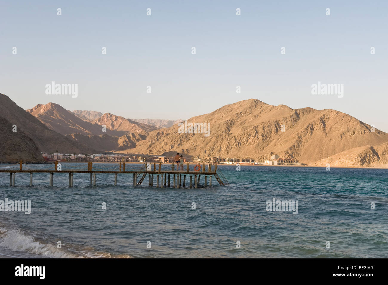 Sunset over Taba Heights, Taba, Sinai,Rea sea, Egypt, Africa, with calm blue waters in the foreground and diving jetty. Stock Photo