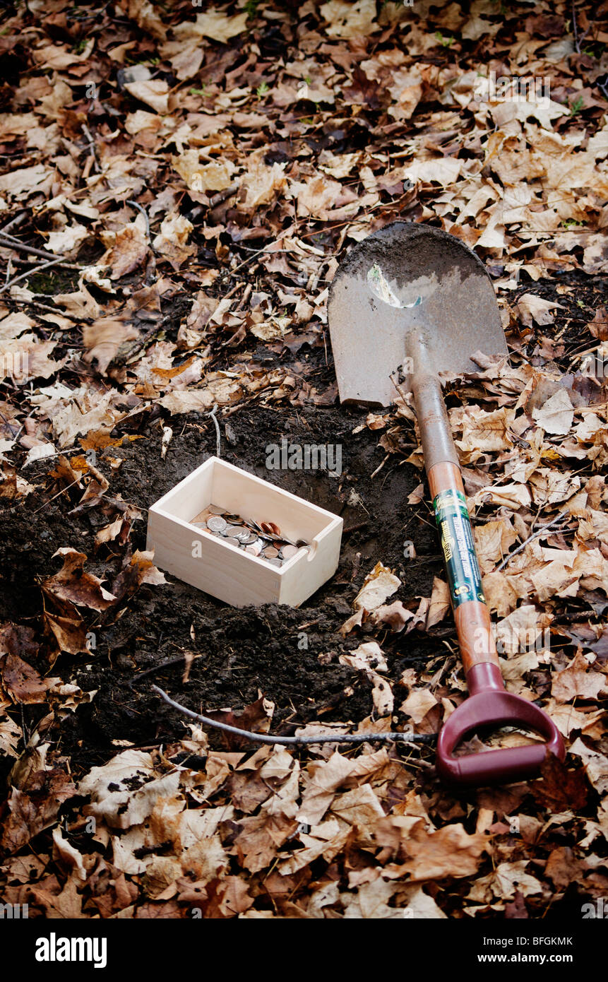 Shovel next to a box filled with money getting buried in the ground