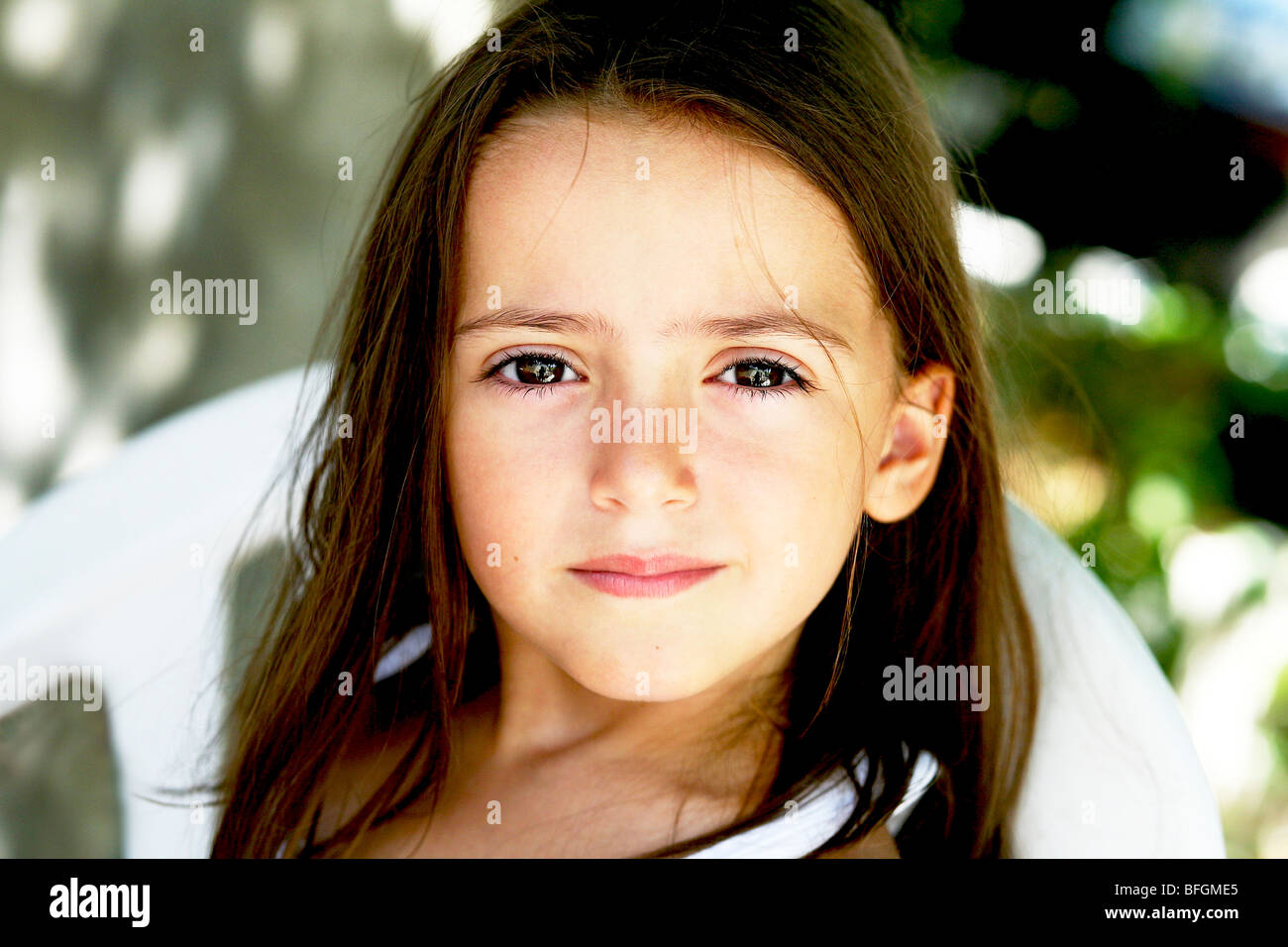 Close-up of young girl with long hair on chair, Limni, Evia Island, Greece Stock Photo