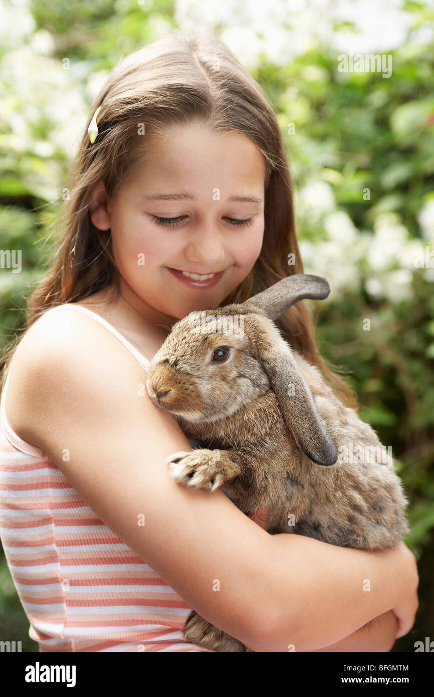 Girl in backyard holding bunny rabbit Stock Photo - Alamy