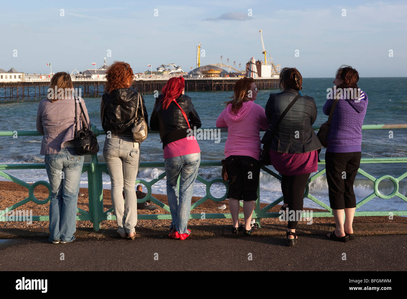 Group of young women looking over to Brighton Pier. Stock Photo