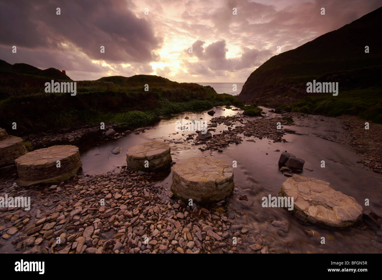 Stepping stones across a small stream leading down to Welcombe Mouth beach on the North Devon coast UK Stock Photo