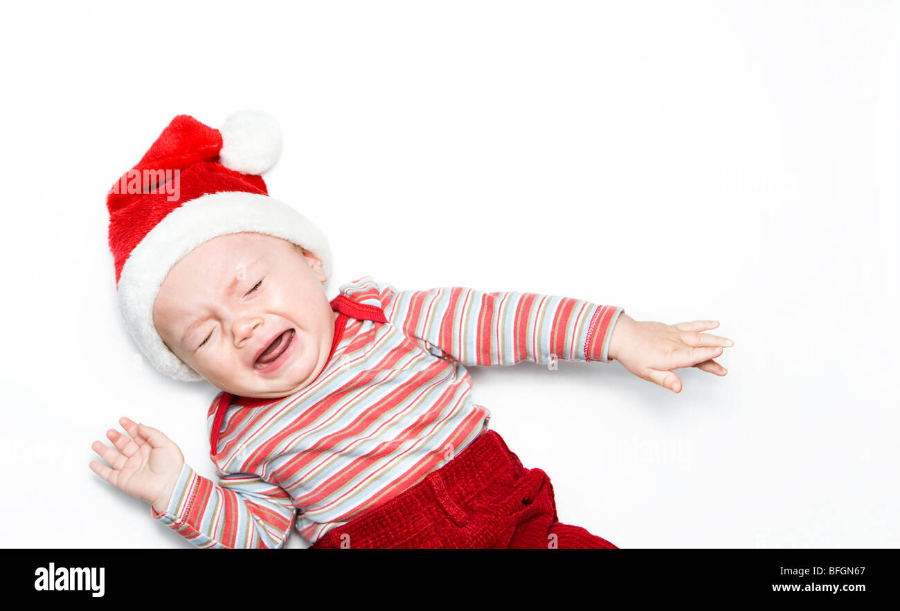 Baby boy wearing santa hat and crying Stock Photo