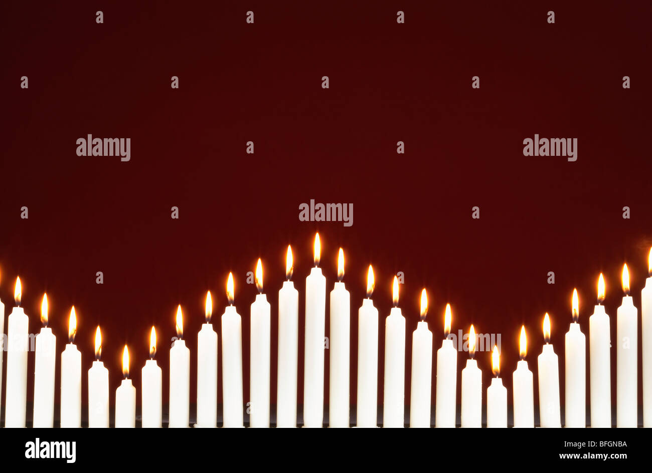 Row of lit candles, on black background Stock Photo - Alamy